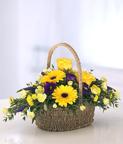 Yellow and Purple Basket - A vibrant basket of Gerberas roses and other seasonal blooms arranges in a lovely Seagrass basket